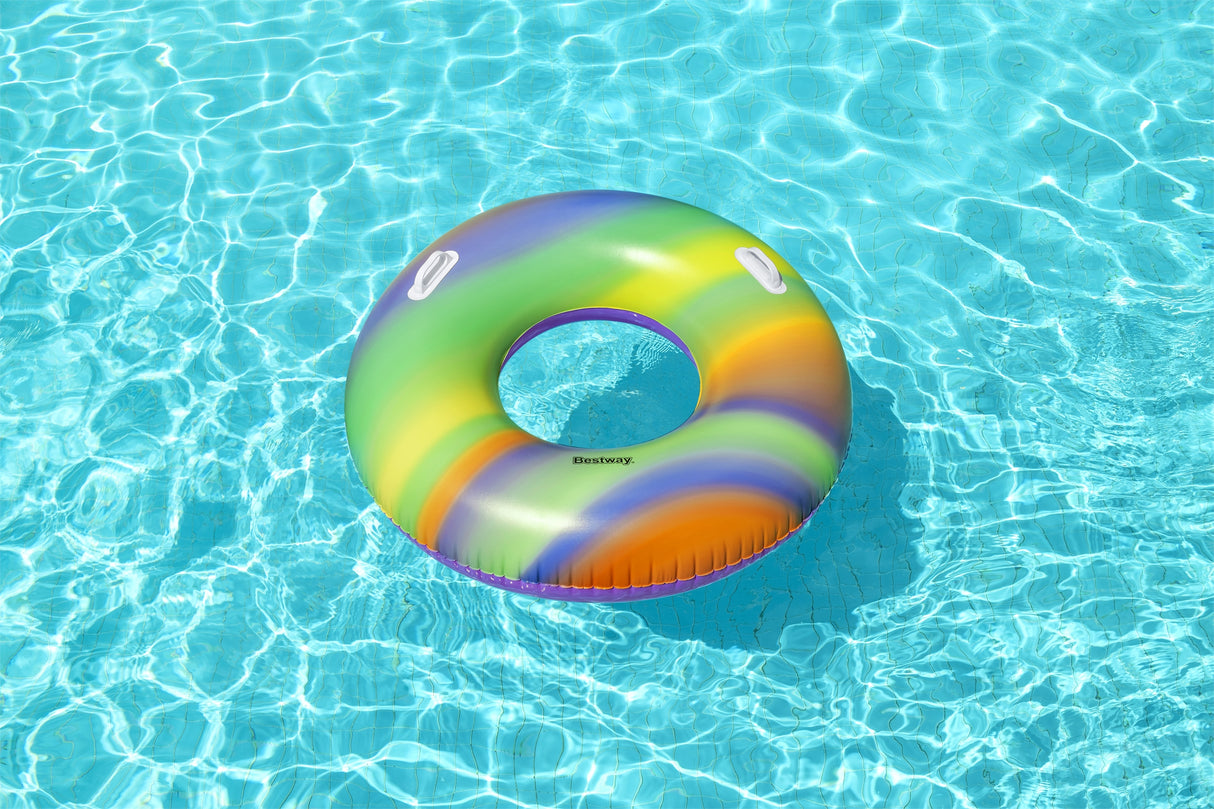 This is a lifestyle image showing the rainbow swim ring resting atop water.