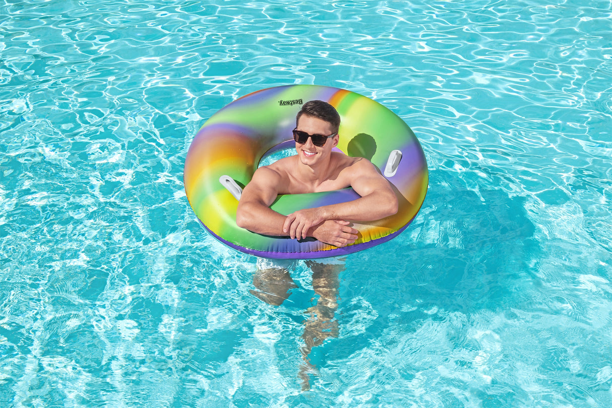 This is a lifestyle image showing a man inside the inner tube in a pool.