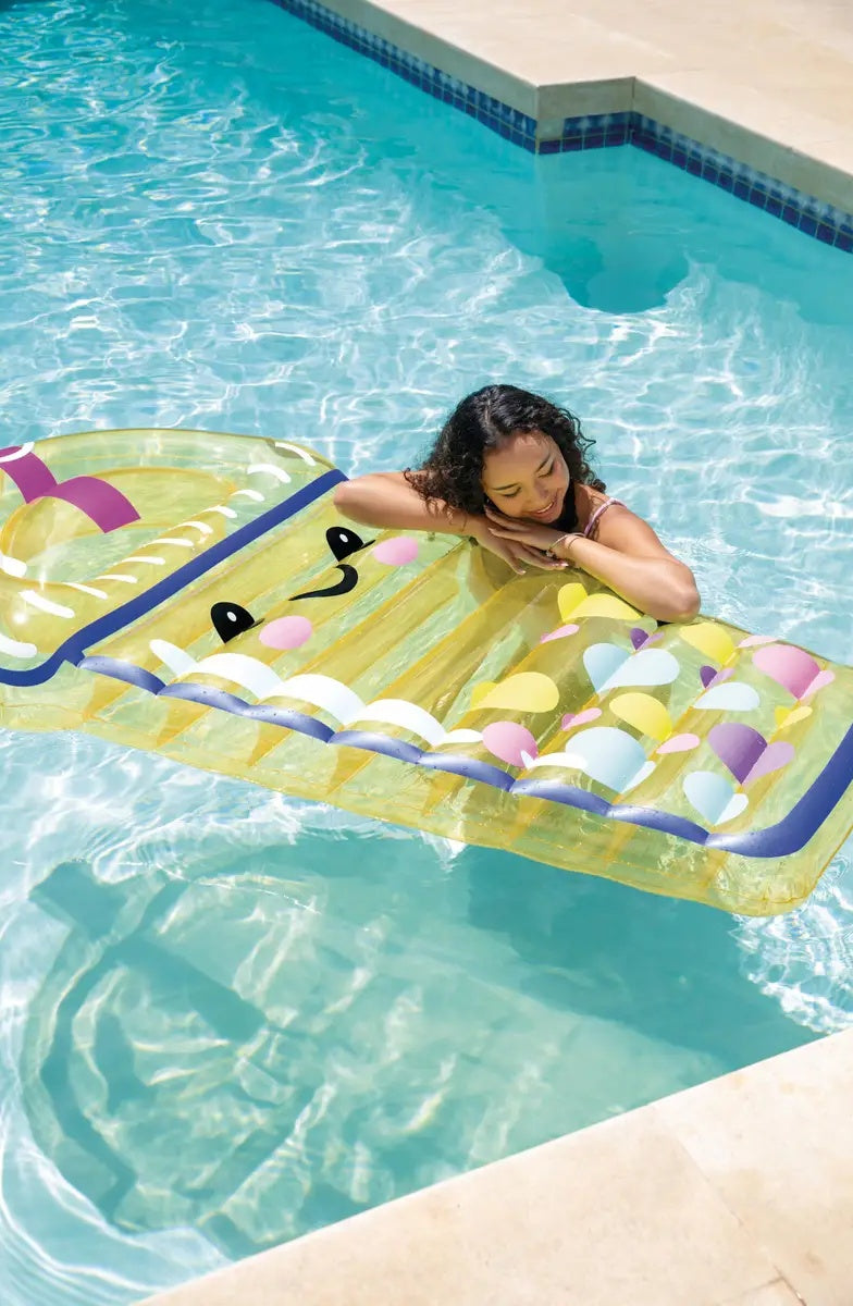 This is a lifestyle image showing a girl leaning on the boba shaped pool inflatable.