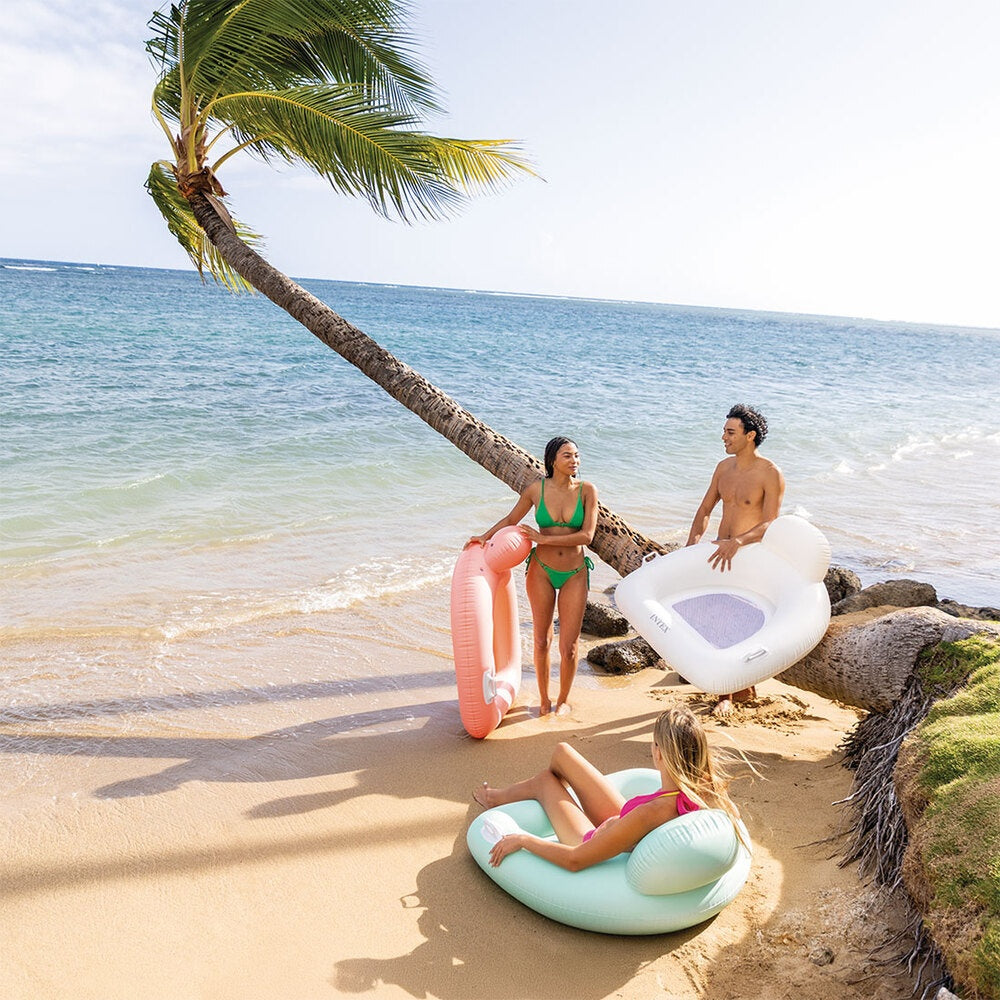 This is a lifestyle image showing three adults on a beach holding these inflatable chairs.