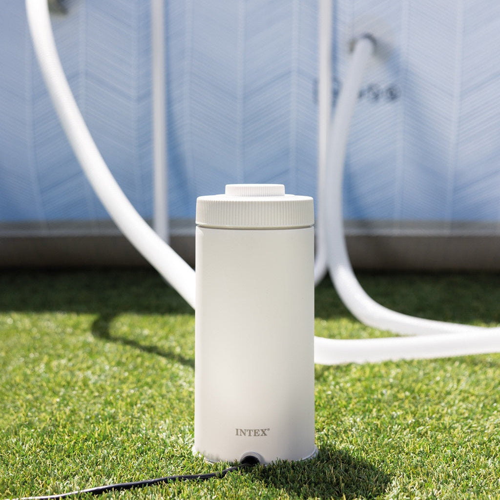This is a lifestyle image showing the pool filter on the grass next to an Intex pool.