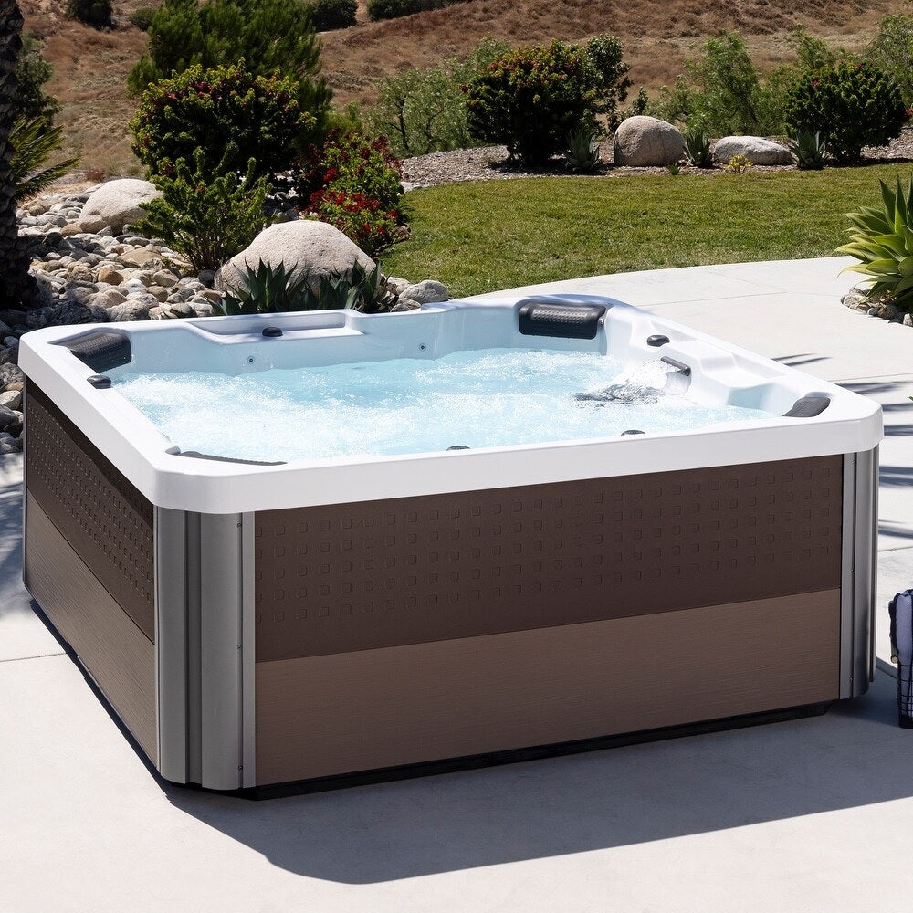 This is a lifestyle image showing the side of the hot tub and the colors: Dark Brown and Light Brown.