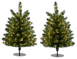 This image shows the two small pre-lit trees on a white background. They both have black stands.