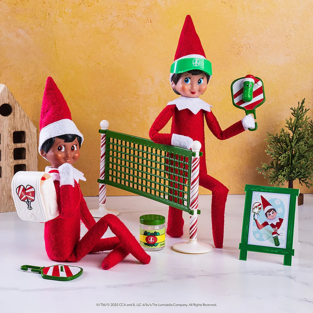 This is a lifestyle image showing two Scout Elves playing pickleball in front of a small tree.