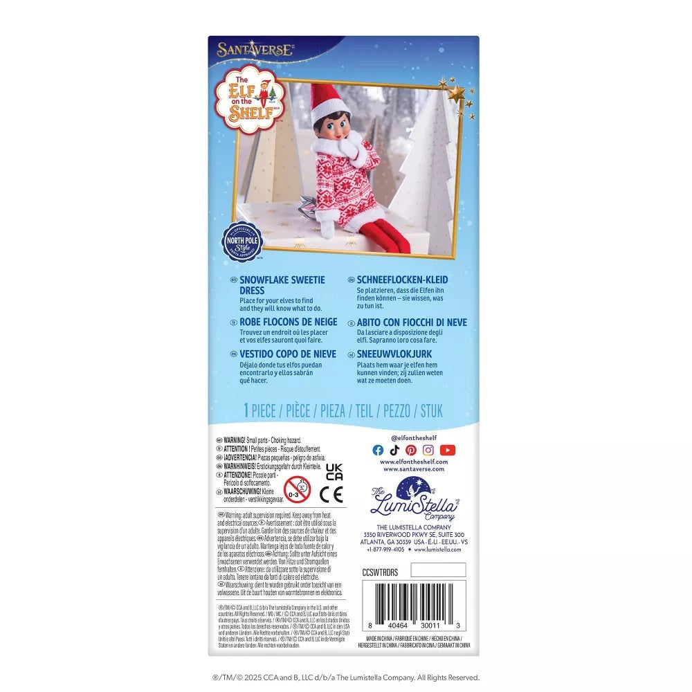 This image shows the back of this packaging. It reads "Santaverse. The Elf on the Shelf. Snowflake Sweetie Dress. Place for your elves to find and they will know what to do."