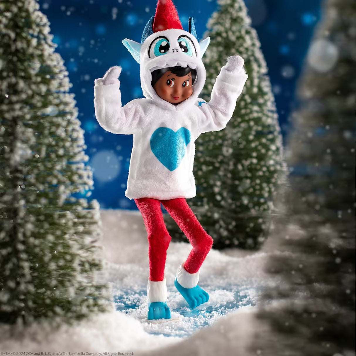 This is a lifestyle image showing a Scout Elf wearing the Yeti monster hoodie and boots and dancing among small snow covered trees.