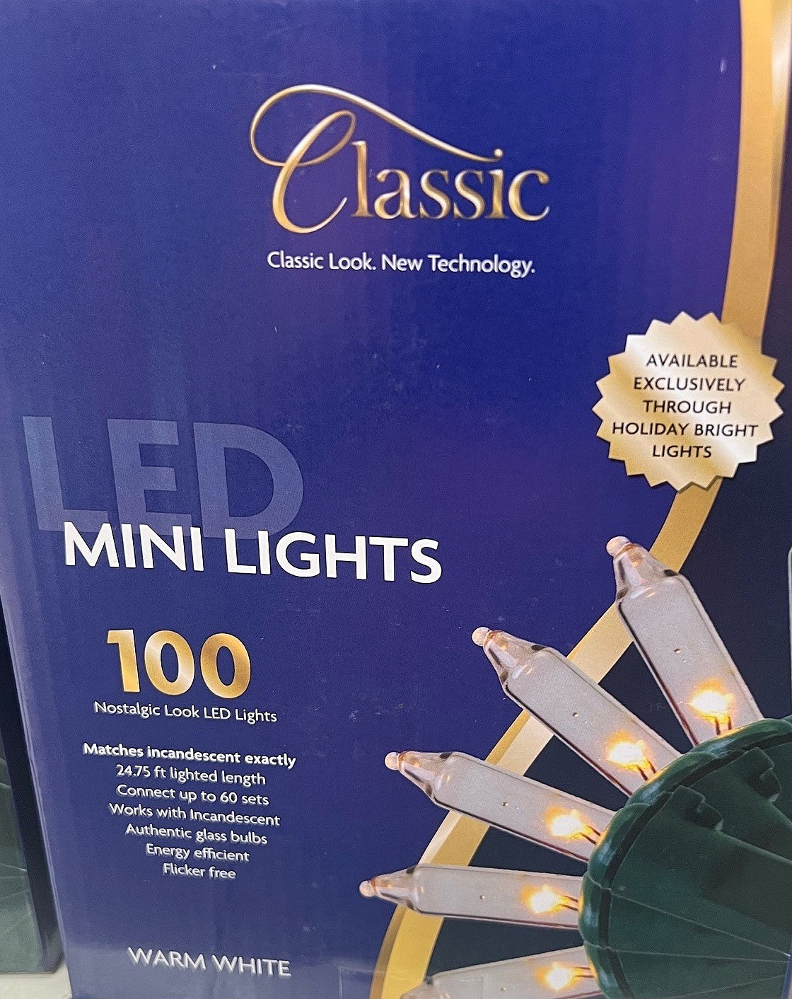 This image shows the box that the warm white lights come in. It reads "Classic look, new technology. LED Mini Lights. Available exclusively through Holiday Bright Lights. 100 nostalgic-look LED lights. Matches incandescent exactly. 24.75 ft. lighted length. Connect up to 60 sets. Works with incandescent authentic glass bulbs. Energy-efficient. Flicker free."