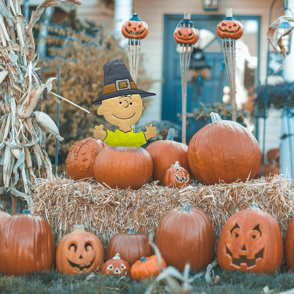 This is a lifestyle image showing it sticking out from inside a pumpkin that's next to a bunch of other pumpkins on a bale of hay. Some of the pumpkins are carved with silly and spooky faces.