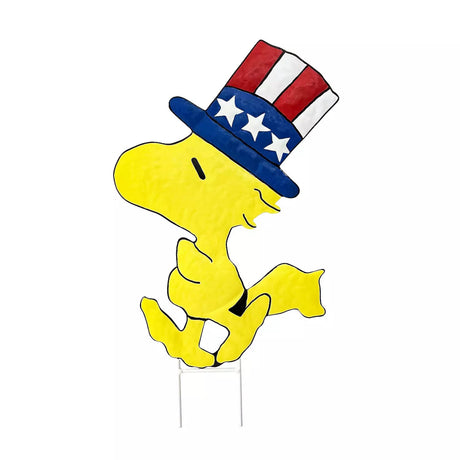 This is image shows a garden stake shaped like the Peanuts character Woodstock. He's wearing a red, white and blue top hat.