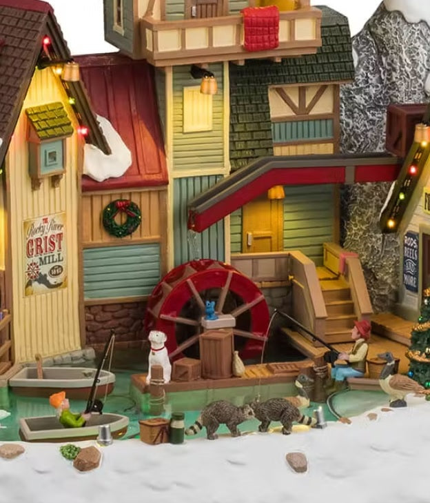 This is an up close view of this building. The sign reads "Rocky River Grist Mill." There's a decorated wreath above the mill.