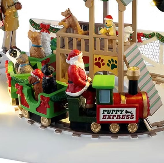 This is an up close view of the train. You can see Santa Claus driving and all different kinds of dogs in each car. There's a small play area in the middle of the tracks where dogs are playing.