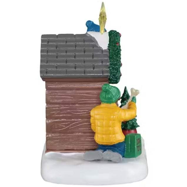 This is a different angle of this table accent. The girl is wearing a green hat and gloves, a yellow jacket, blue jeans and gray shoes.