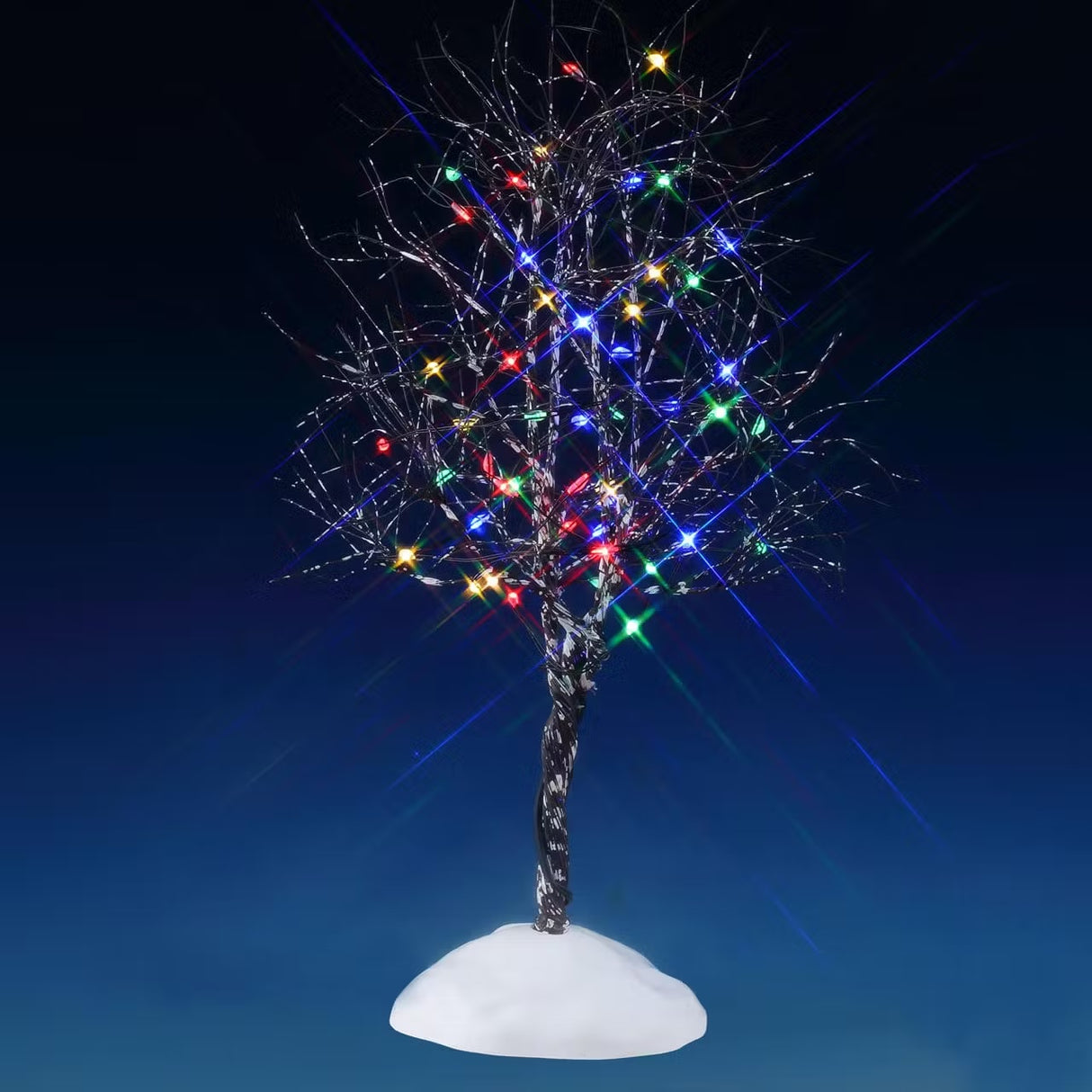 This is a Lemax lighted tree. It's pre-lit with multi-colored lights. The branches are skinny and bare and designed to look like there's snow on them. This is showing it on a blue background.