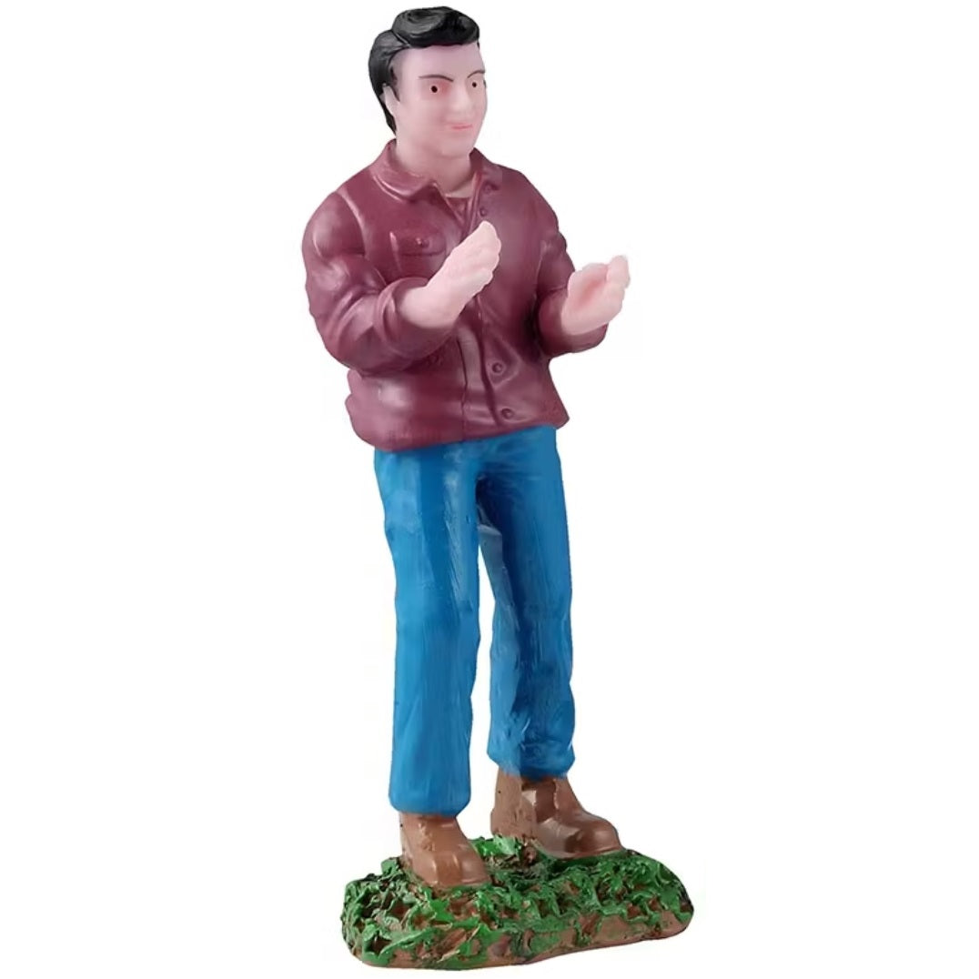 This figurine is a man wearing a maroon colored shirt and blue jeans and he's clapping his hands together.