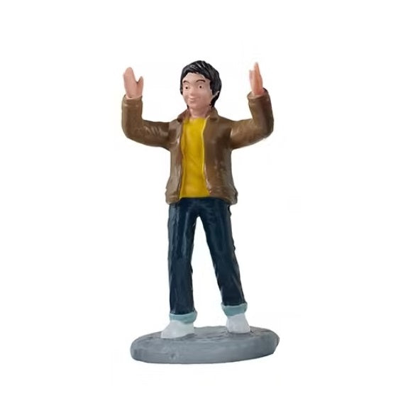 This figurine is of a boy smiling and clapping his hands in the air.
