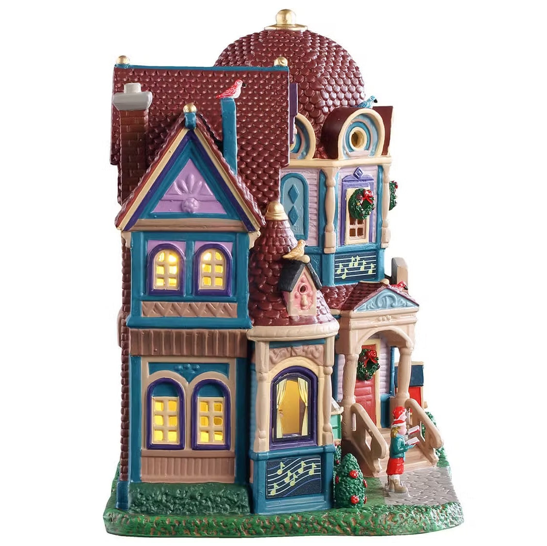 This is the side of the building. There are lots of windows with light shining through. The house has tons of different colors like purple, blue, brown, tan and red.