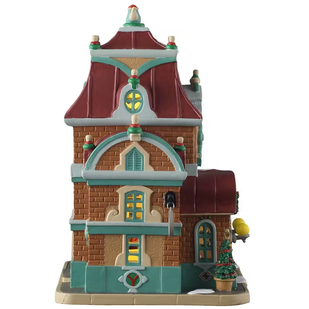 This is the other side of the building. There are four windows with lights shining through. There's a potted tree next to the front door.