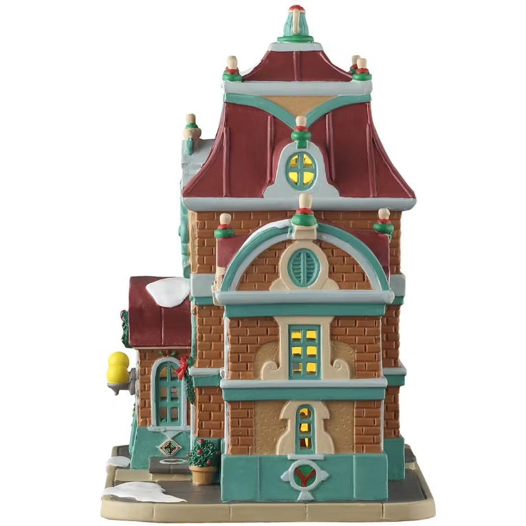 This is the side of the building. There are three windows with lights shining through.