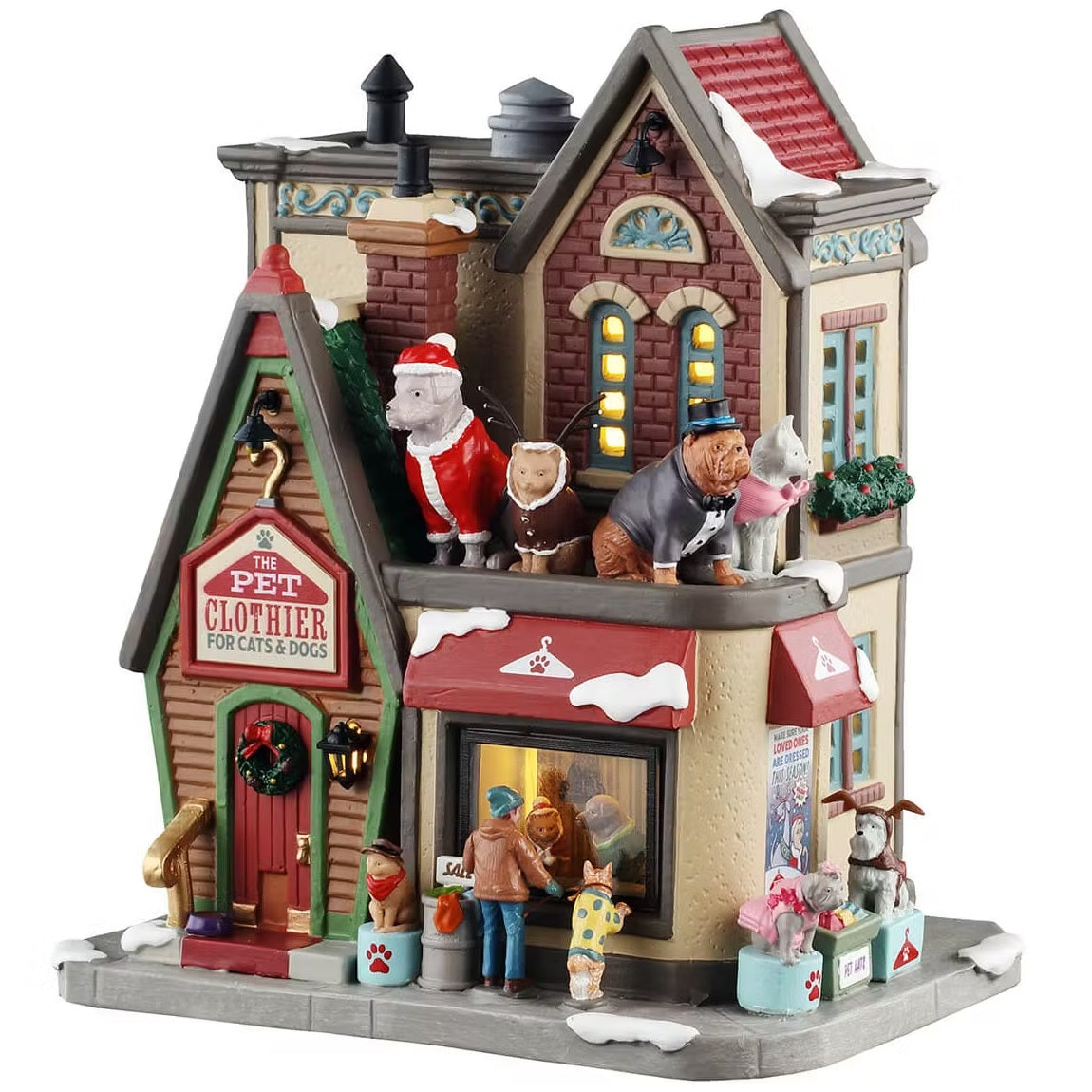 This is a Lemax lighted building designed to look like a tall, brick shop. On top near the roof, there are four statues: one is a dog dressed as Santa, one is a cat dressed as a reindeer, one is a dog wearing a tuxedo and top hat and one is a cat wearing a pink sweater. There are pets dressed up on the sidewalk: one is a cat wearing a hat and a red bandana, one is a dog wearing a polka dot sweater, one is a dog dressed as a ballerina and one is a dog wearing reindeer ears.