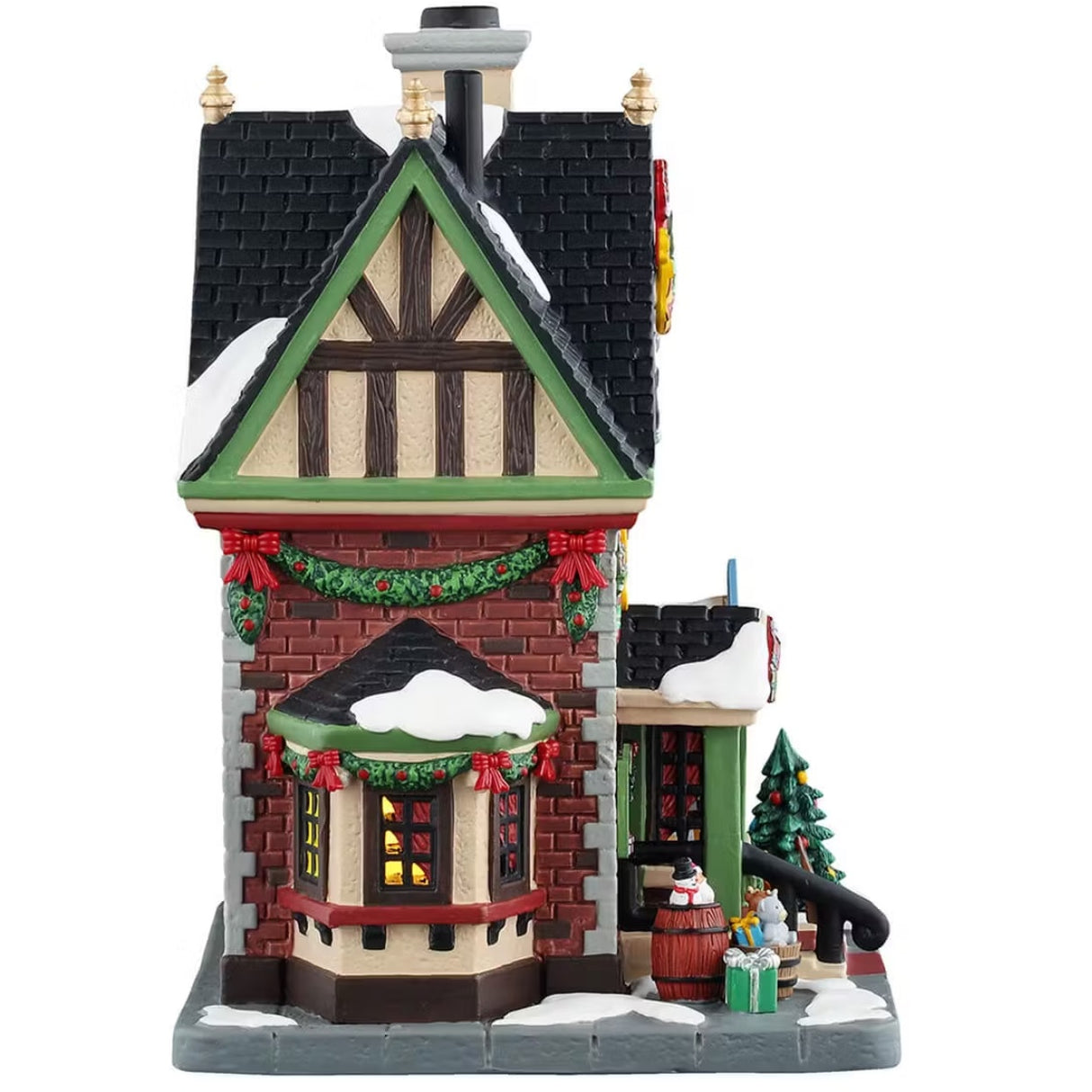 This is the side of the building. There's snow on the roof and on the sidewalk. There's decorated garland hanging on the wall and around the windows.