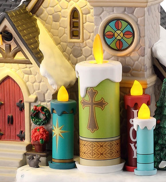 This is an up close view of the candle statues There's a wreath next to the church's red front door. There's also a little squirrel looking up at the candles.