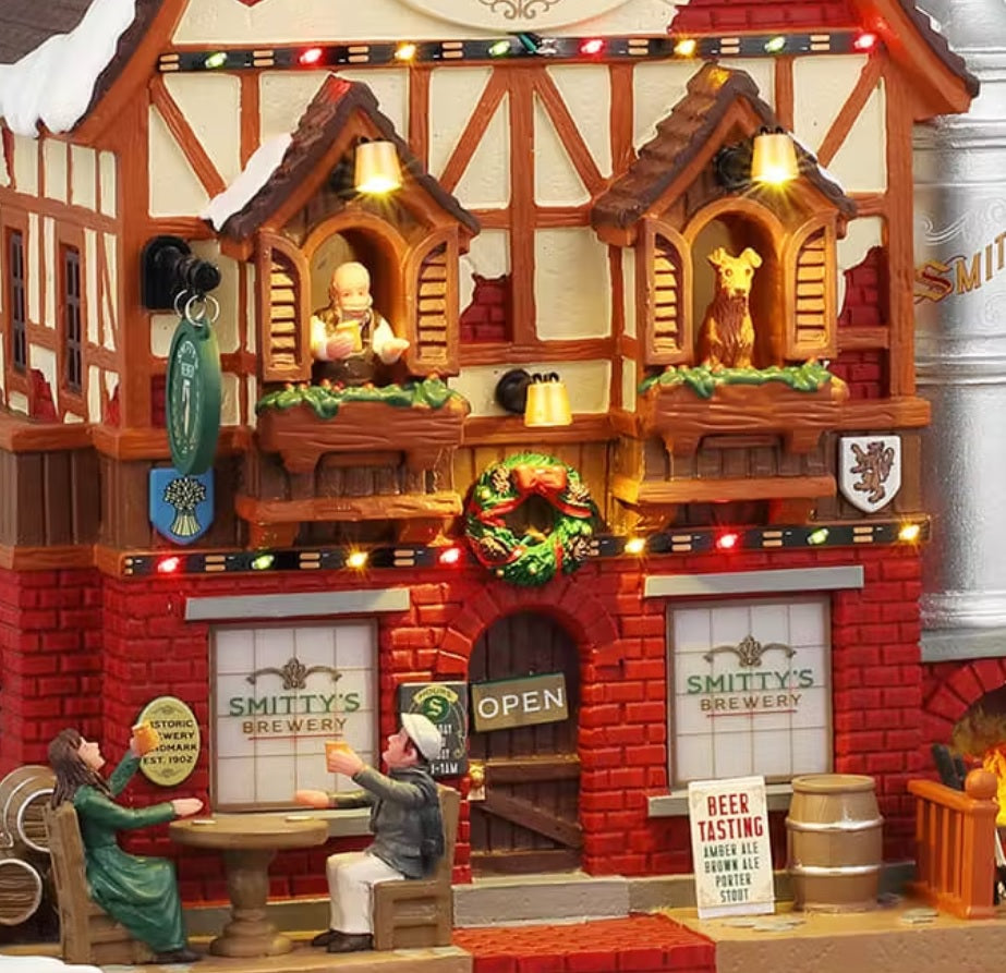 This is a close up look at Smitty's Brewery. There are lights everywhere and a decorated wreath. There's a sign on the sidewalk that reads "Beer Tasting. Amber Ale, Brown Ale, Porter, Stout."