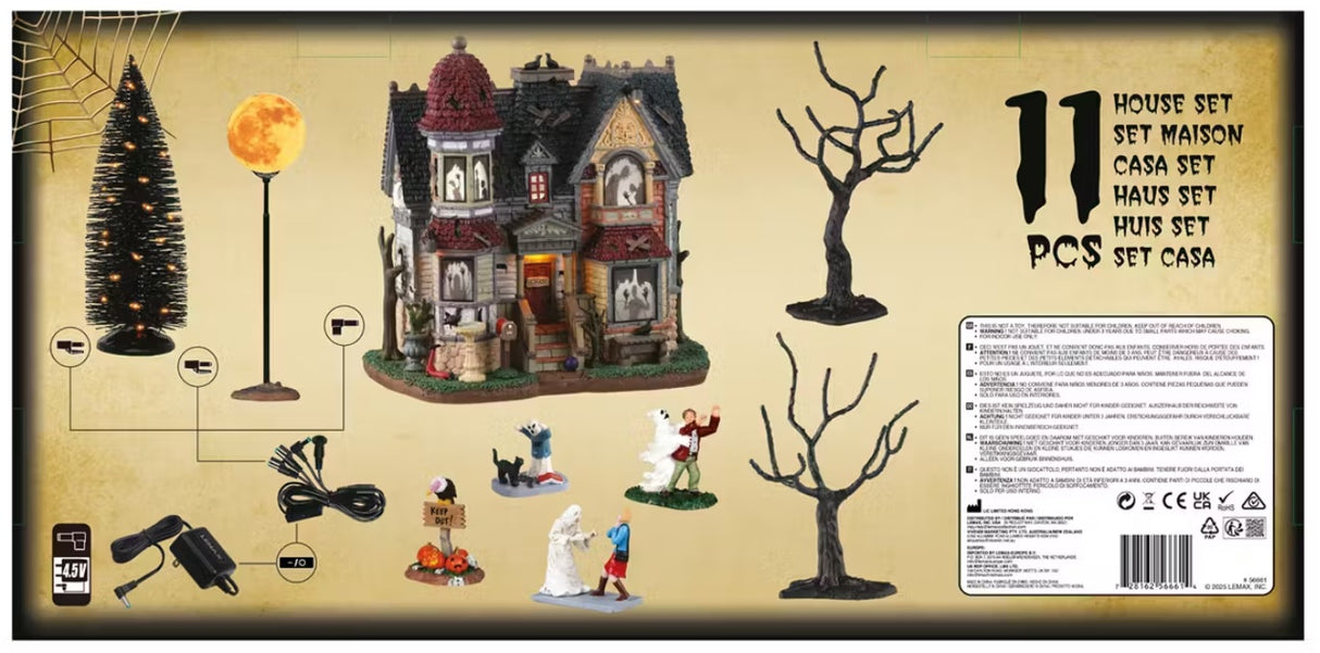 This image shows off the box that this Lemax House Set comes in. It shows the 11 pieces that come with it: three spooky trees, four figurines, one lighted building, one lighted accessory that looks like the moon and two adaptors.