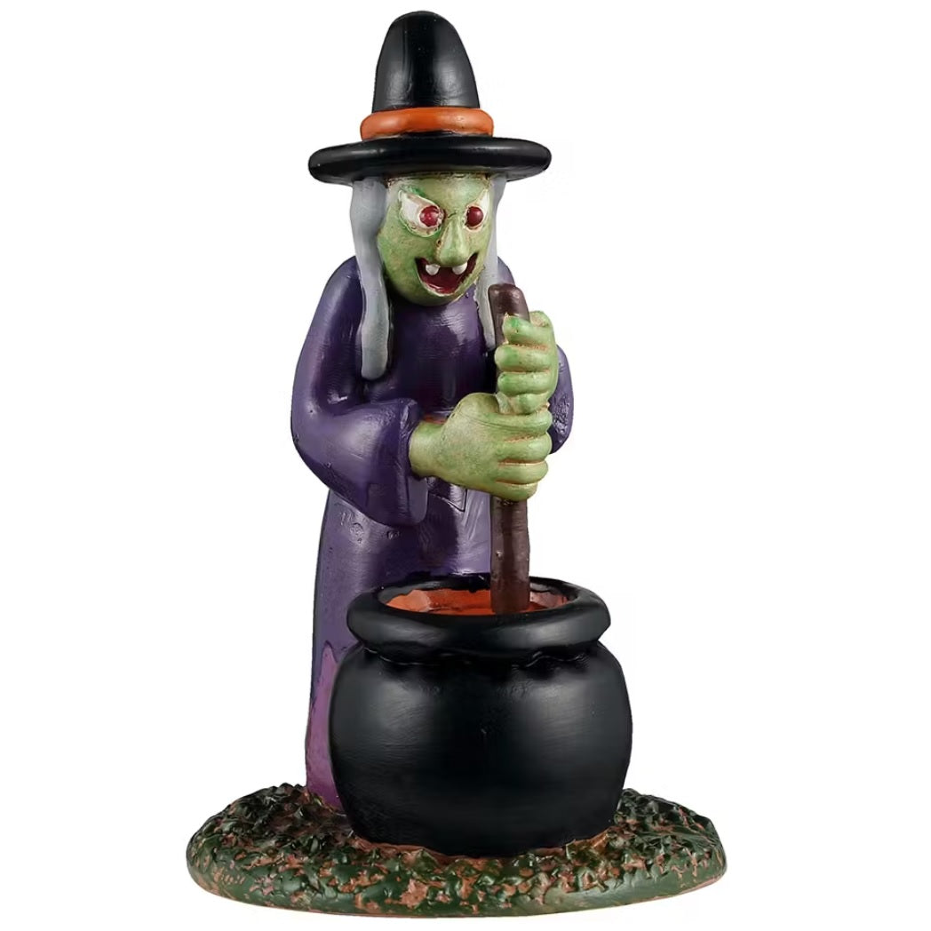 This is a Lemax Spooky Town figurine designed to look like an inflatable witch decoration. She's got a black and orange hat, a purple cloak, gray hair and red eyes. She's stirring the cauldron that's in front of her.