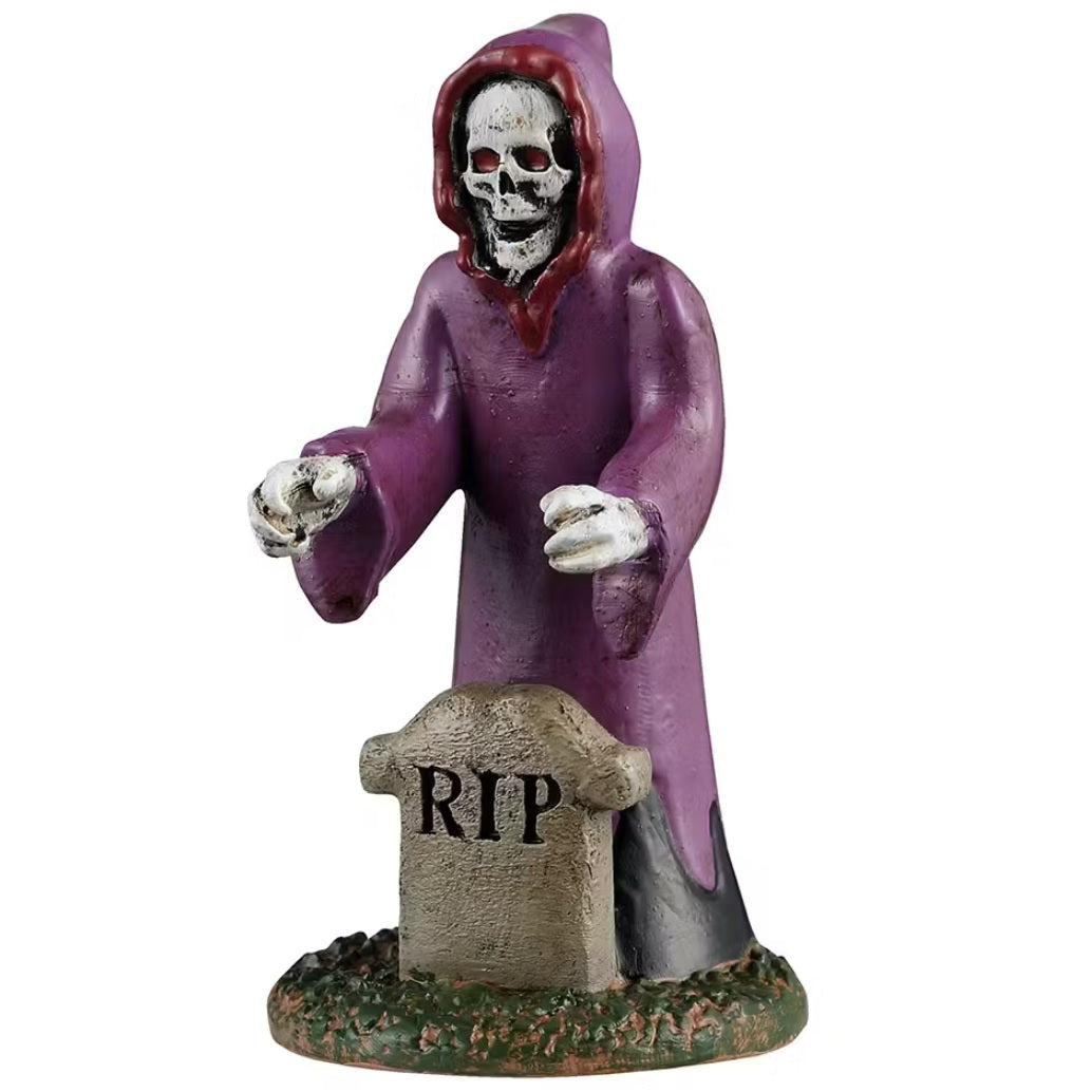 This is a Lemax Spooky Town figurine designed to look like an inflatable Grim Reaper yard decoration. He's wearing a purple and red cloak and has bright red eyes. In front of him stands a small tombstone that reads RIP.