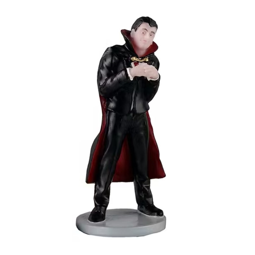 One of the kids is dressed up like a vampire, wearing a black leather outfit and a black and red colored cloak.