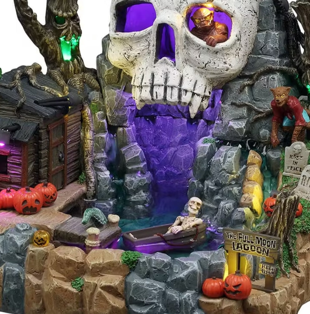 This is an up close view of this Full Moon Lagoon showing a skeleton using a coffin as a boat on the water. There's a monster crawling out of the giant cave skull's eye and a werewolf standing off to the side among some tombstones.