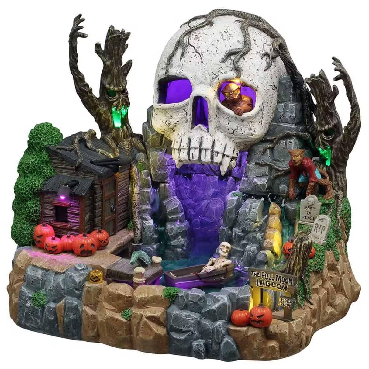 This is a Lemax Spooky Town table accent designed to look like a lagoon hidden among a bunch of rocks and boulders. There's a rundown shack on the left with a bunch of jack-o-lanterns next to it. There are two trees with glowing faces on them. The entrance to the cave is shaped like a big skull with purple eyes.