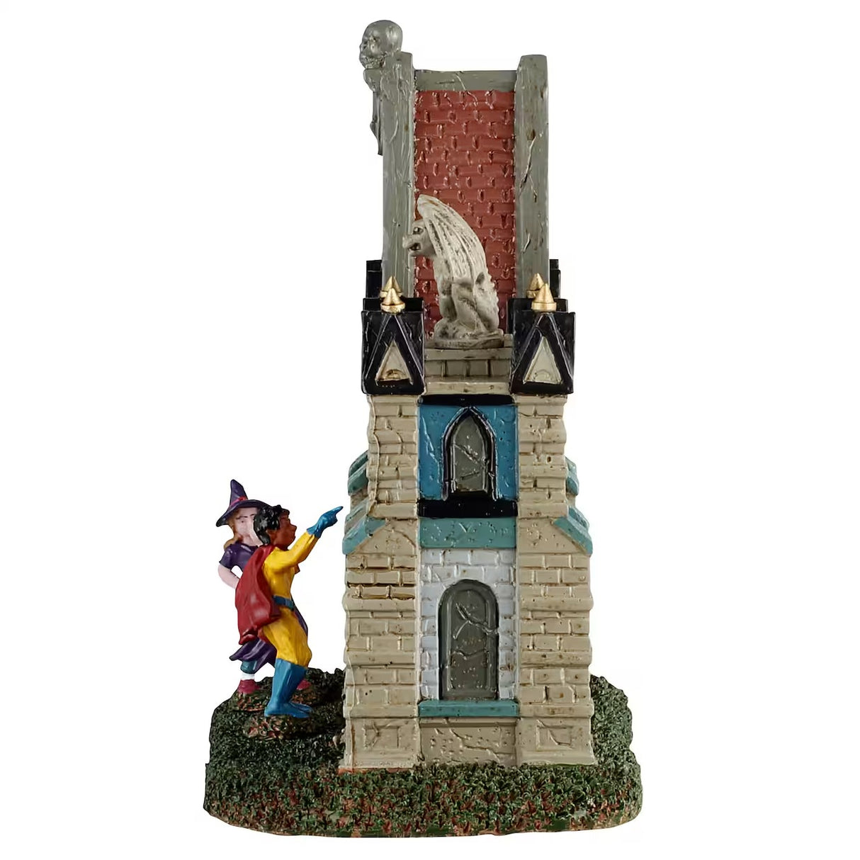 This is a different angle of the Lemax Spooky Town table accent designed to look like a Gothic gate. There are gargoyles and skeletons and pointed columns. There are also two trick or treaters trying to get in. One is dressed like a purple witch and the other is dressed like a superhero with a red cape.
