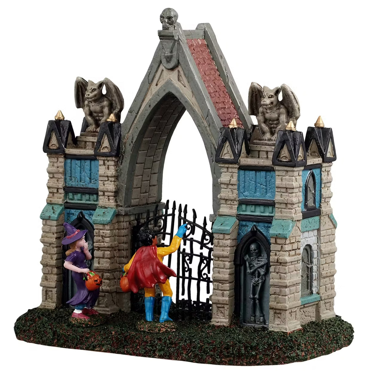 This is a Lemax Spooky Town table accent designed to look like a Gothic gate. There are gargoyles and skeletons and pointed columns. There are also two trick or treaters trying to get in. One is dressed like a purple witch and the other is dressed like a superhero with a red cape.