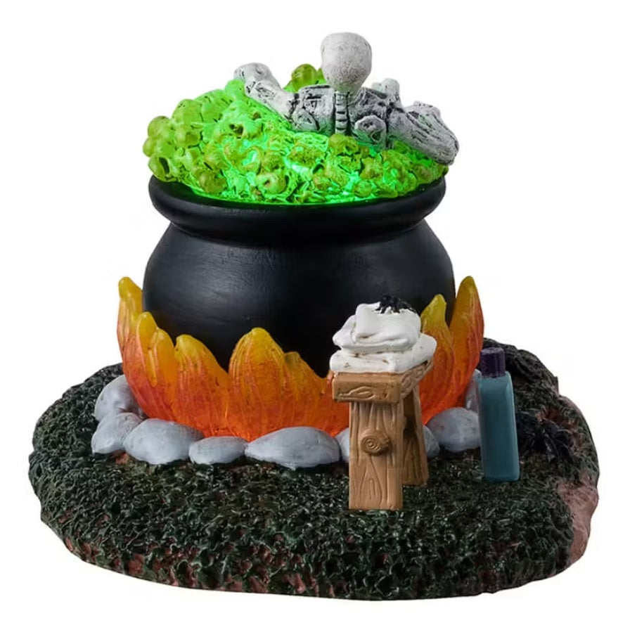 A different angle - This is a Lemax Spooky Town table accent designed to look like a skeleton taking a bath in a big, black cauldron. The water glows green. There's a stool with a towel and a spider on it. Next to the cauldron, there's a tube of Spa Bath Soap. There's a sign next to the cauldron that reads "Esmeralda's Spa featuring Relaxing Hot Tub Cauldron Baths. But don't stay in the water too long!"
