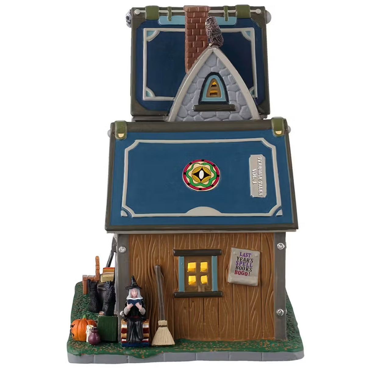 This is the side of the building. The book/roof reads "TERRIBLE TALES VOL. 1" and has an ouroboros logo on it. There's a witch sitting on a stack of books next to a broom. There's an owl on the roof.