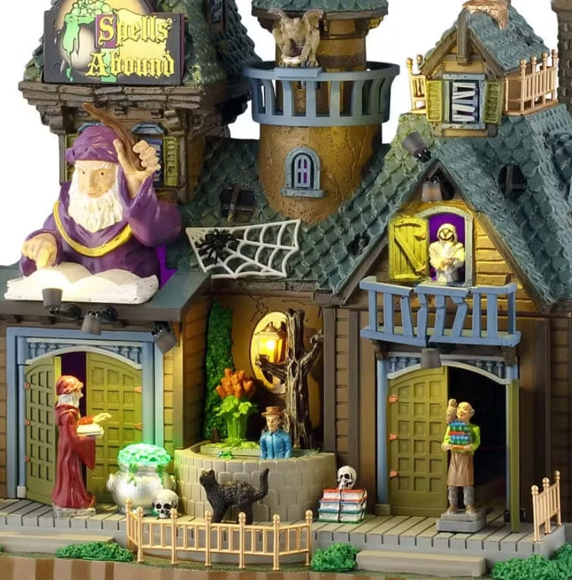 This is an up close view of the Spells Abound Lemax building. You can see a gargoyle near the roof, a spider with a web on the roof and a monster peering out from one of the windows.