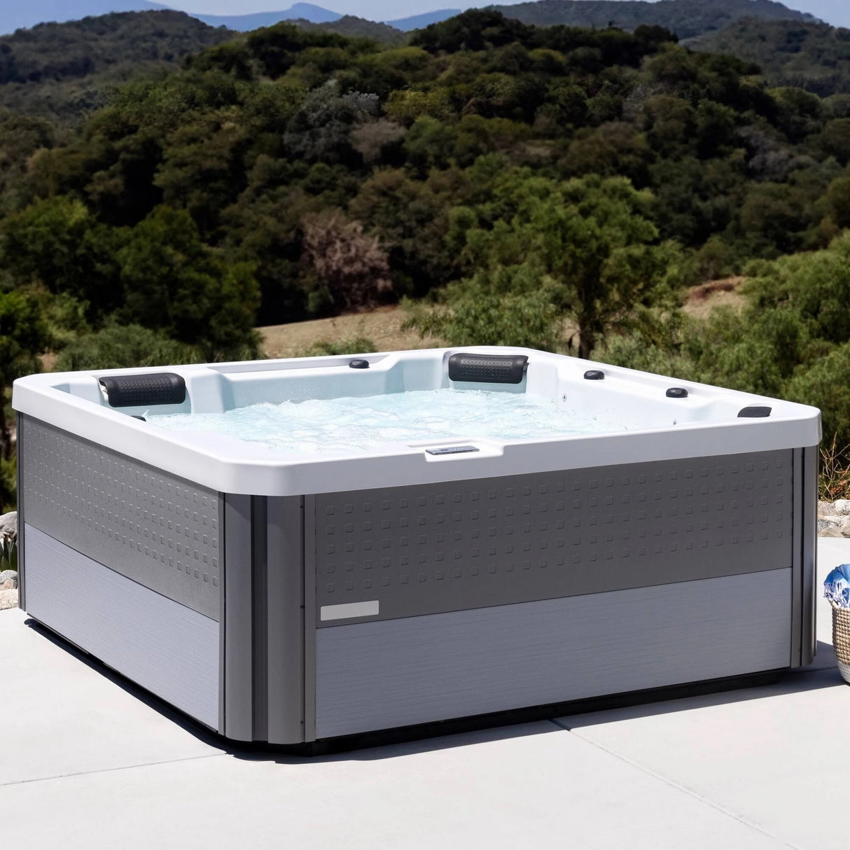 This is a lifestyle image of the filled hot tub on a patio in an exotic location.