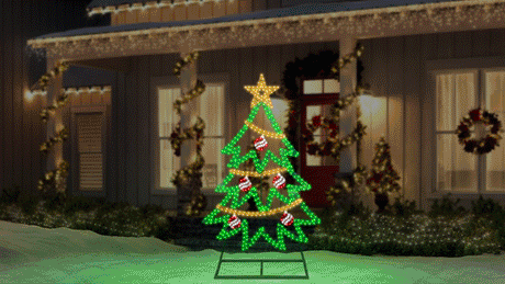 This animated image shows the twinkling tree decoration on a snowy yard in front of a house decorated for Christmas.
