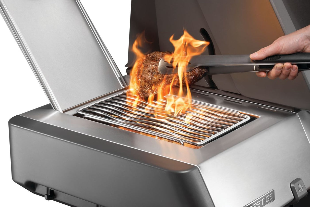 This is an up close view of someone flipping a steak that's cooking on the left side burner.