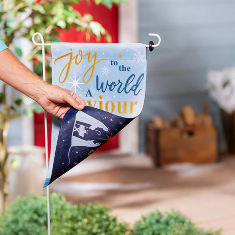 A flag with a design on the front that reads "Silent night, holy night, all is calm, all is bright" in a mixture of cursive and normal printing. The design on the back reads "Joy to the world, a savior is born" in a mixture of cursive and normal printing.