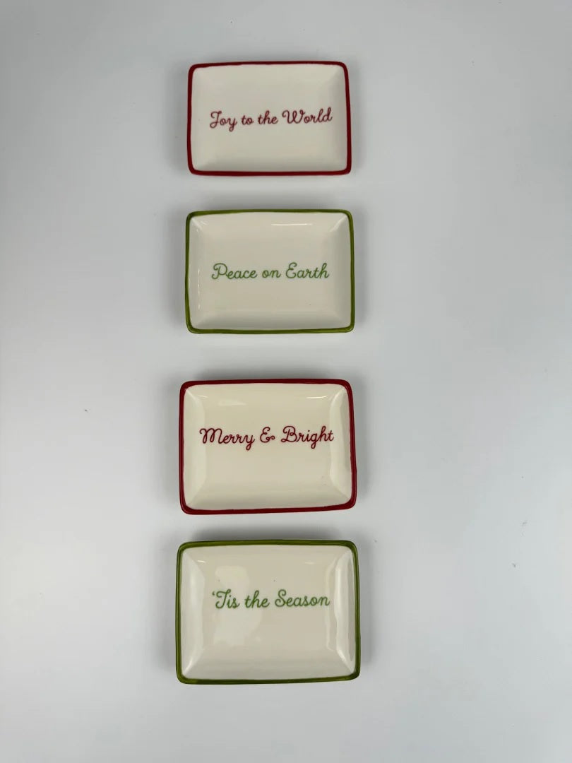 Decorative stoneware dish. One dish reads "Tis the Season" and has a green border. One dish reads "Merry & Bright" and has a red border. One dish reads "Peace on Earth" and has a green border. One dish reads "Joy to the World" and has a red border.