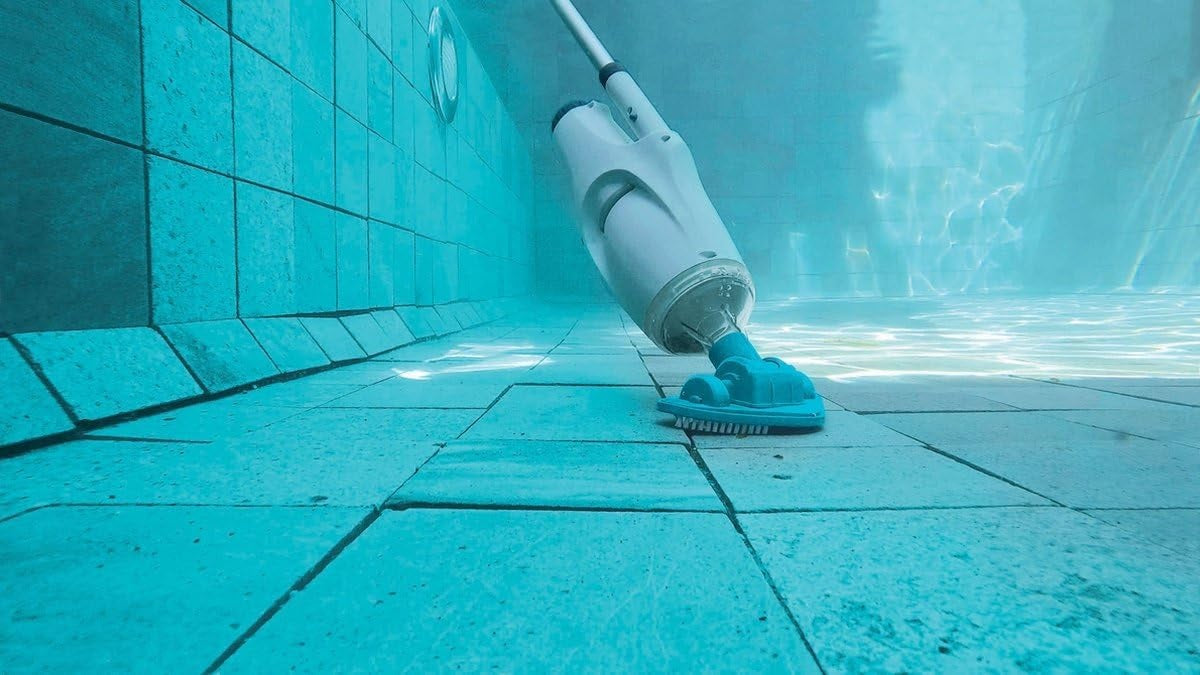 Handheld pool vacuum. The body is white and gray and the head is a neon blue color. It has white bristles to brush the pool liner. This image shows what the vacuum looks like under water.