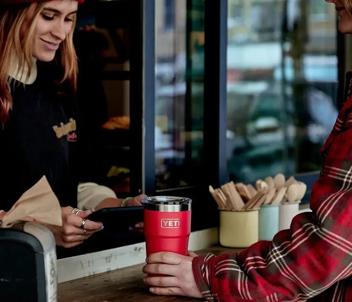 This lifestyle image shows someone holding the Tropical Pink colored Yeti Rambler cup.