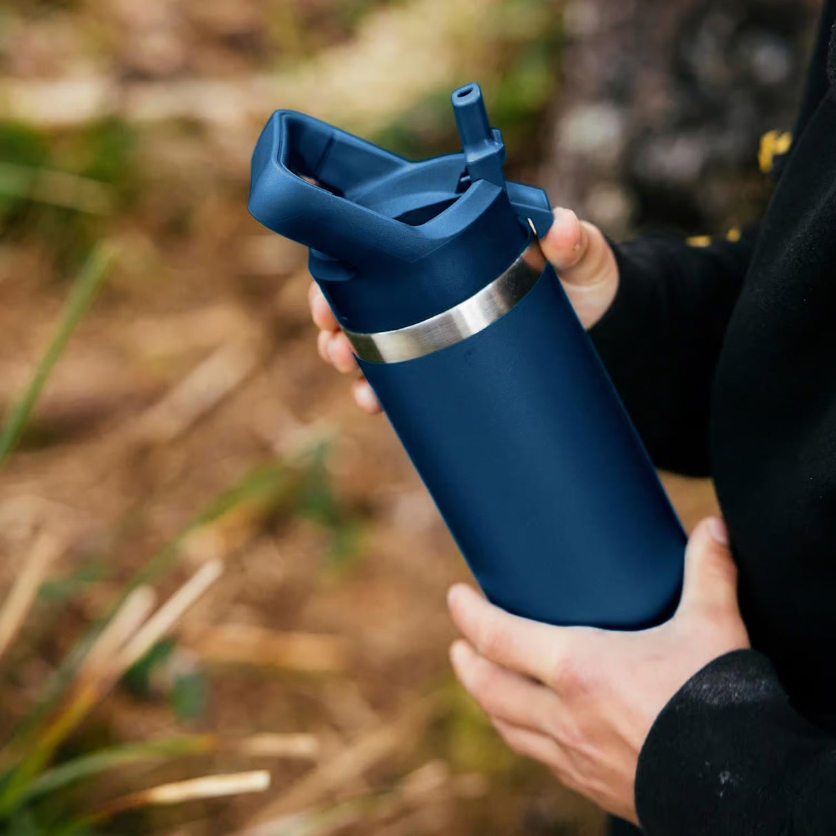 Navy colored YETI water bottle. This lifestyle image shows someone holding it.