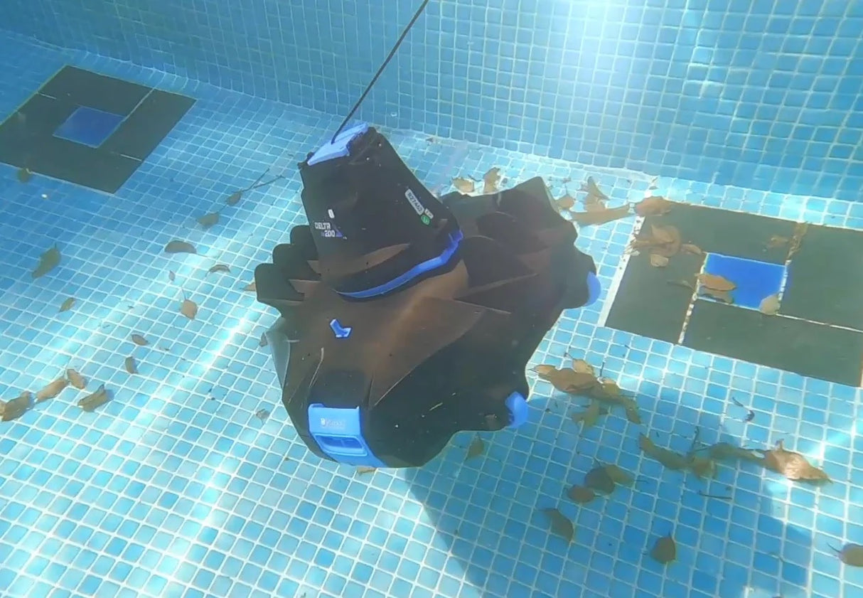 Cordless robotic pool vacuum. Body is black with hints of blue. This is an image showing the cleaner underwater.