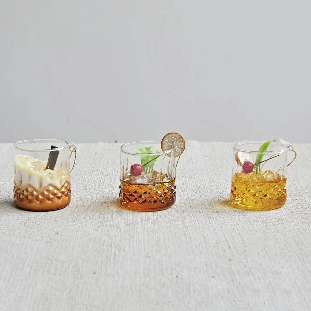 Cocktail shaped ornament. Crafted in the shape of a low ball whiskey glass. One ornament is a tequila sunrise. One ornament is a mudslide. One ornament is an old-fashioned.