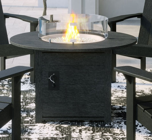 A round black resin fire pit table between four chairs