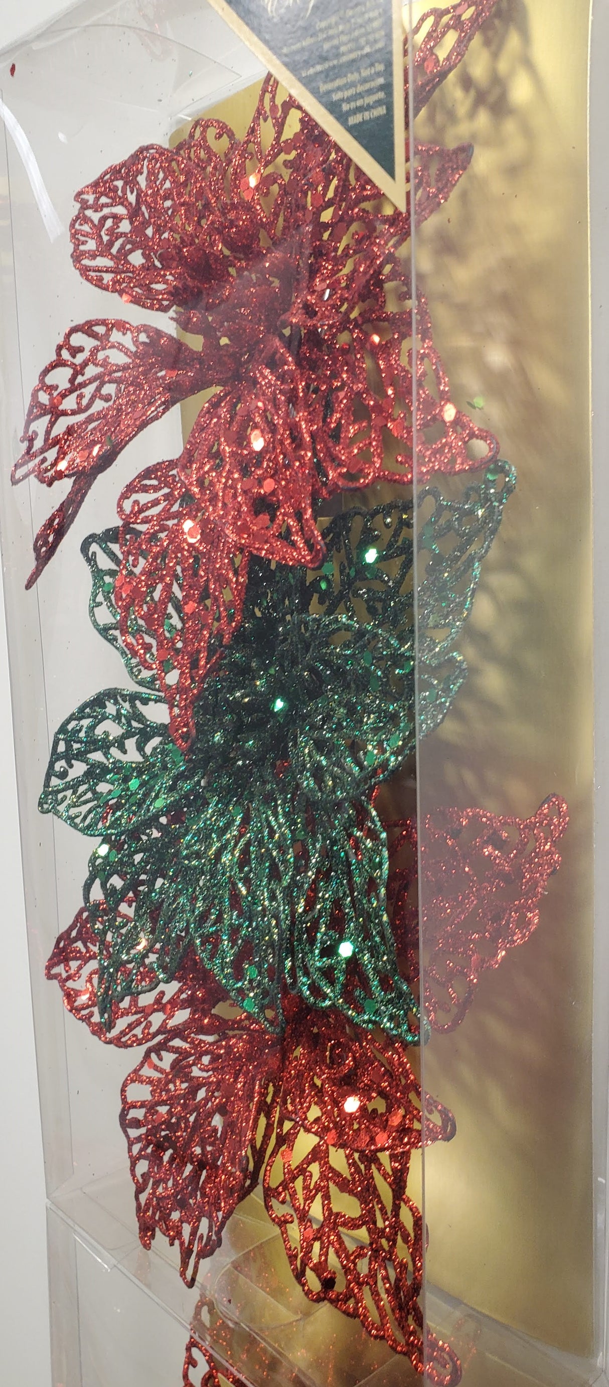 Clip on ornaments. One set of three features all red poinsettias. One set of three feature two red poinsettias and one green poinsettia. One set of three features two red poinsettias and one gold poinsettia. One set of three features one red, one gold and one green poinsettia.