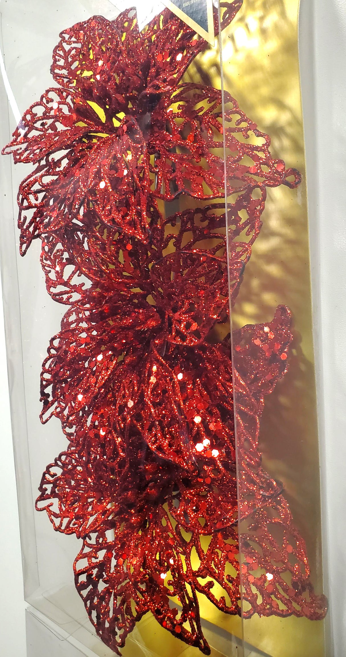 Clip on ornaments. One set of three features all red poinsettias. One set of three feature two red poinsettias and one green poinsettia. One set of three features two red poinsettias and one gold poinsettia. One set of three features one red, one gold and one green poinsettia.